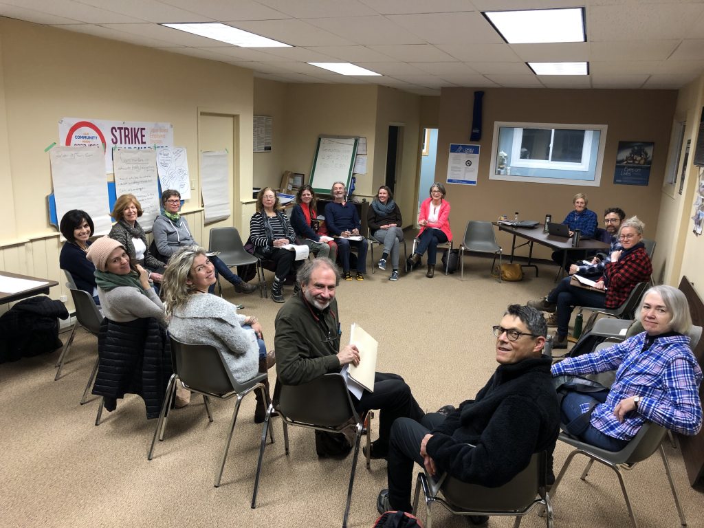 Group of about 20 people sitting in circle.