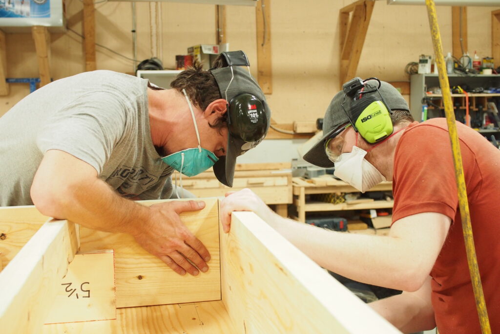Two carpenters building a wall panel